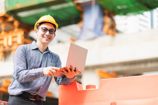 Smiling marine engineer on site working using a laptop